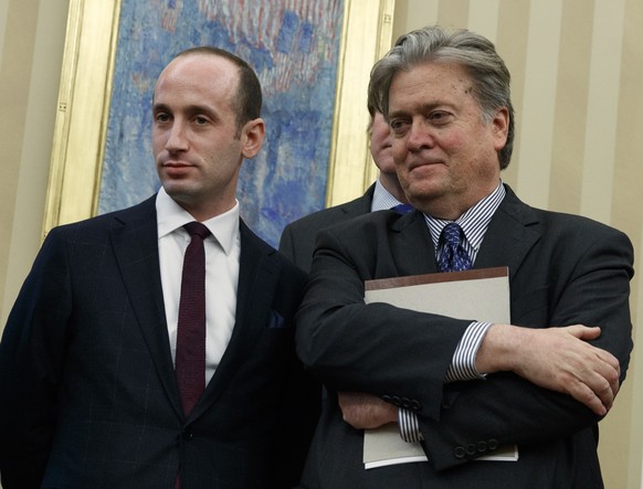 From left, Senior Adviser Jared Kushner, policy adviser Stephen Miller, and chief strategist Steve Bannon watches as President Donald Trump signs an executive order to withdraw the U.S. from the 12-na ...