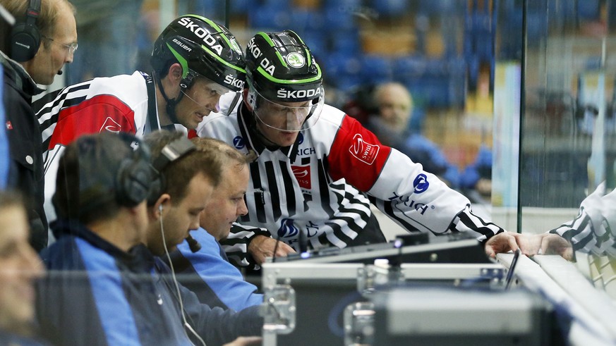 Schiedsrichter Michael Kueng, links, und Schiedsrichter Daniel Stricker schauen sich die TV-Bilder an vom ersten Treffer der Kloten Flyers zum 1-0 waehrend dem Eishockey-Meisterschaftsspiel der Nation ...