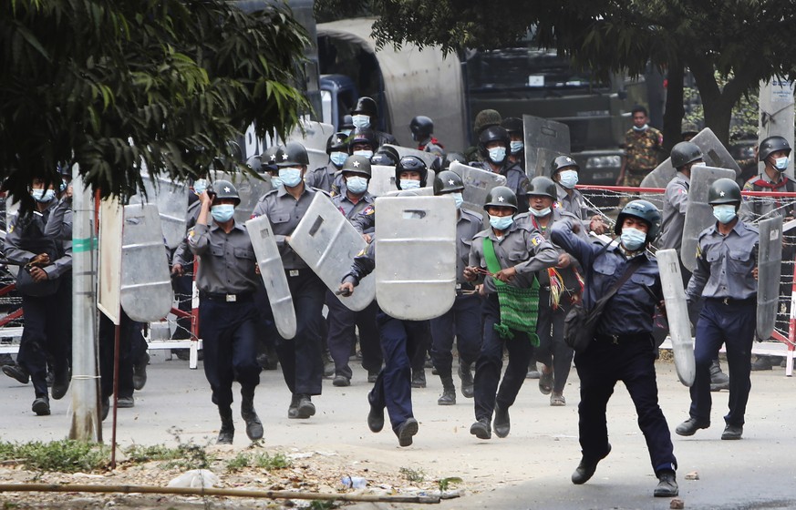 Police charge forward to disperse protesters in Mandalay, Myanmar on Saturday, Feb. 20, 2021. Security forces in Myanmar ratcheted up their pressure against anti-coup protesters Saturday, using water  ...