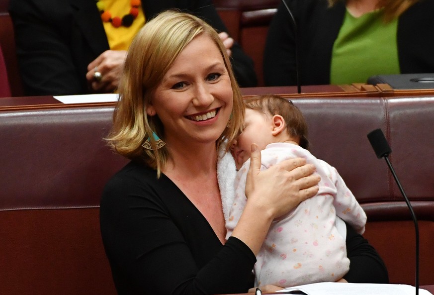 epa05954002 Greens Senator Larissa Waters soothes baby Alia Joy after breastfeeding her during a division in the Senate Chamber at Parliament House in Canberra, Australian Capital Territory, Australia ...