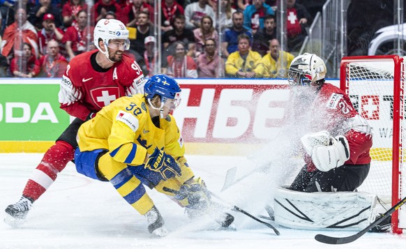 epa07582532 Switzerland&#039;s Roman Josi (L) and goalkeeper Reto Berra (R) in action against Sweden&#039;s Oskar Lindblom (C) during the match between Sweden and Switzerland at the IIHF Ice Hockey Wo ...