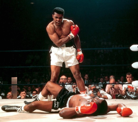 Heavyweight champion Muhammad Ali, then known as Cassius Clay, stands over fallen challenger Sonny Liston, shouting and gesturing shortly after dropping Liston with a short hard right to the jaw on Ma ...