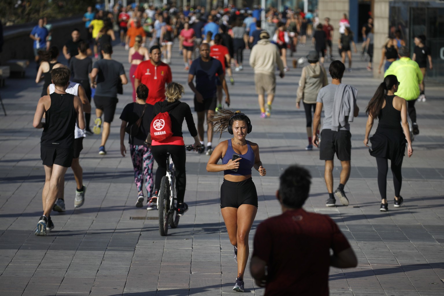 People exercise on a seafront promenade in this photo taken with a telephoto lens in Barcelona, Spain, Saturday, May 2, 2020. Spaniards have filled the streets of the country to do exercise for the fi ...