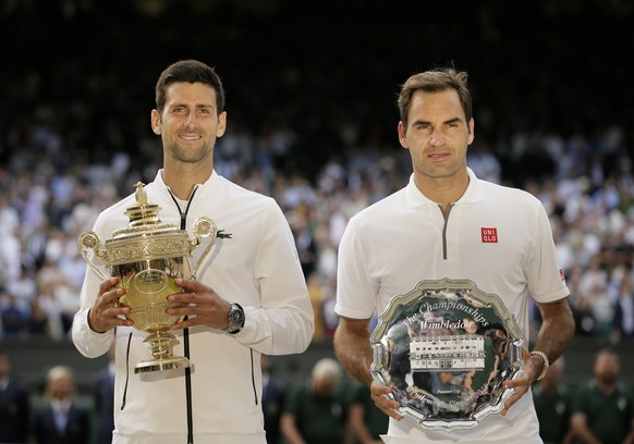FILE - Serbia&#039;s Novak Djokovic, left, and Switzerland&#039;s Roger Federer pose with the trophies after the men&#039;s singles final match of the Wimbledon Tennis Championships in London, in this ...
