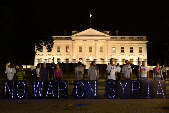 epa03861941 Opponents of a possible military strike on Syria hold a sign that reads &#039;No War On Syria&#039;, as they gathered outside the White House to listen to US President Barack Obama give a  ...