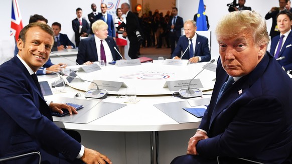 epa07792013 French President Emmanuel Macron (L) and US President Donald Trump (R) attend a G7 working session on &#039;International Economy and Trade, and International Security Agenda&#039; during  ...