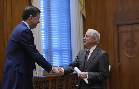 Attorney General Jeff Sessions, left, shares hands with FBI Director James Comey, left, at the start of a meeting with the heads of federal law enforcement components at the Department of Justice in W ...