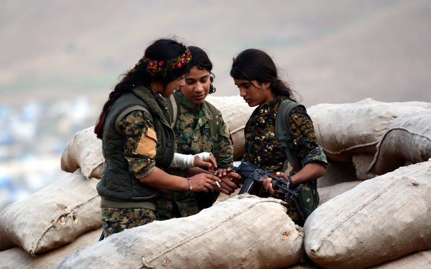 epa06664477 Syrian and Iraqi Kurdish female fighters of the Women&#039;s Protection Units (YPJ) and Rojava Defence Units take up position at a military barracks near the northern Iraqi town of Sinjar, ...