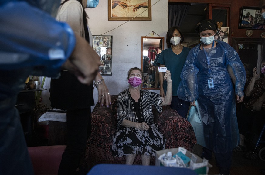 Filomena Zuleta, 70, holds up her vaccination card after she was injected with a dose of China&#039;s Sinovac Biotech COVID-19 vaccine, in her family&#039;s home in Santiago, Chile, Thursday, Feb. 25, ...