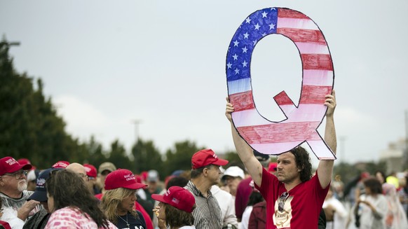 FILE - In this Aug. 2, 2018, file photo, a protesters holds a Q sign waits in line with others to enter a campaign rally with President Donald Trump in Wilkes-Barre, Pa. Facebook and Twitter promised  ...