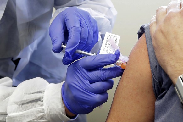 FILE - In this March 16, 2020, file photo, a subject receives a shot in the first-stage safety study clinical trial of a potential vaccine by Moderna for COVID-19, the disease caused by the new corona ...