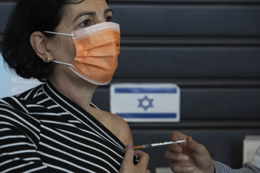An Israeli woman receives a Pfizer-BioNTech coronavirus vaccine at a vaccination center in Tel Aviv, Israel, Tuesday, Feb. 2, 2021. (AP Photo/Sebastian Scheiner)