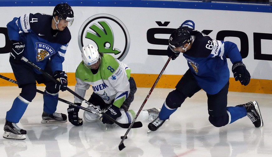 epa05955766 Ziga Jeglic (C) of Slovenia in action against Osala Oskar (R) and Mikko Lehtonen of Finland during the IIHF Ice Hockey World Championship 2017 group B preliminary round game between Finlan ...
