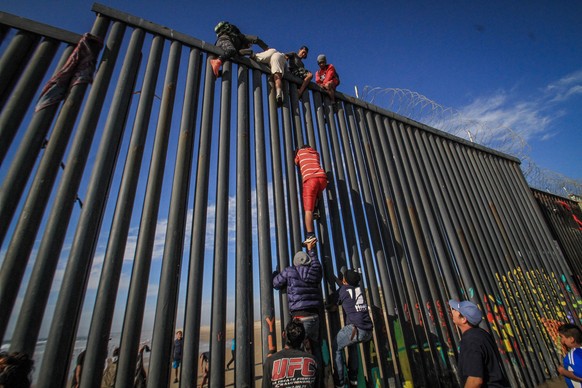 epa07449520 Migrants attempt to enter the United States illegally from the Playas Tijuana area in the Mexican state of Baja California, Mexico, 19 March 2019. According to witnesses, around a hundred  ...