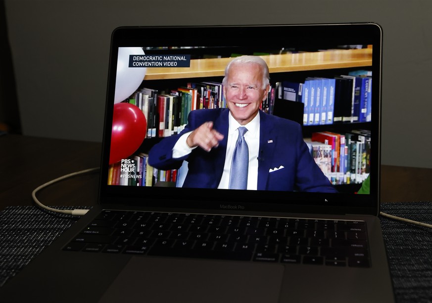 epa08612057 Democratic Presidential nominee Joe Biden is displayed on a computer as he speaks during the virtual Democratic National Convention, in New York City, USA, 18 August 2020. The convention,  ...