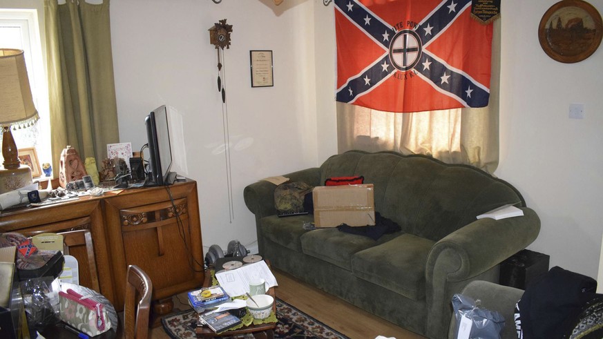 In this undated photo issued Monday Nov. 12, 2018, by Britain&#039;s West Midlands Police, showing Swastika cushions, slightly hidden below, and a Ku Klux Klan flag hanging in the lounge of the home o ...