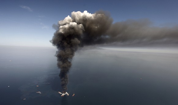 FILE - In this April 21, 2010 file photo, oil can be seen in the Gulf of Mexico, more than 50 miles southeast of Venice on Louisiana&#039;s tip, as a large plume of smoke rises from fires on BP&#039;s ...