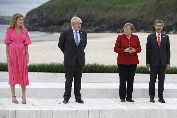 epa09262325 Britain&#039;s Prime Minister Boris Johnson (2-L) and his spouse Carrie Johnson (L) pose with German Chancellor Angela Merkel (2-R) and her spouse Joachim Sauer (R) during the G7 summit in ...