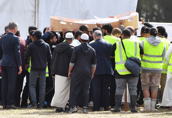 epaselect epa07449334 People carry the caskets of a father and son during the first funerals for victims of the mosque shootings at the Memorial Park Cemetery in Christchurch, New Zealand, 20 March 20 ...