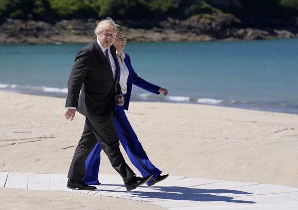 British Prime Minister Boris Johnson and his wife Carrie walk on the boardwalk as they prepare to greet guests during the G7 meeting at the Carbis Bay Hotel in Carbis Bay, St. Ives, Cornwall, England, ...