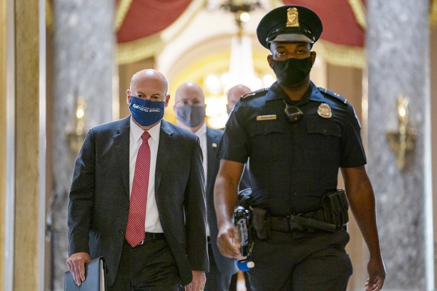 FILE - In this Aug. 5, 2020, file photo Postmaster General Louis DeJoy, left, is escorted to House Speaker Nancy Pelosi&#039;s office on Capitol Hill in Washington. Several individuals including candi ...