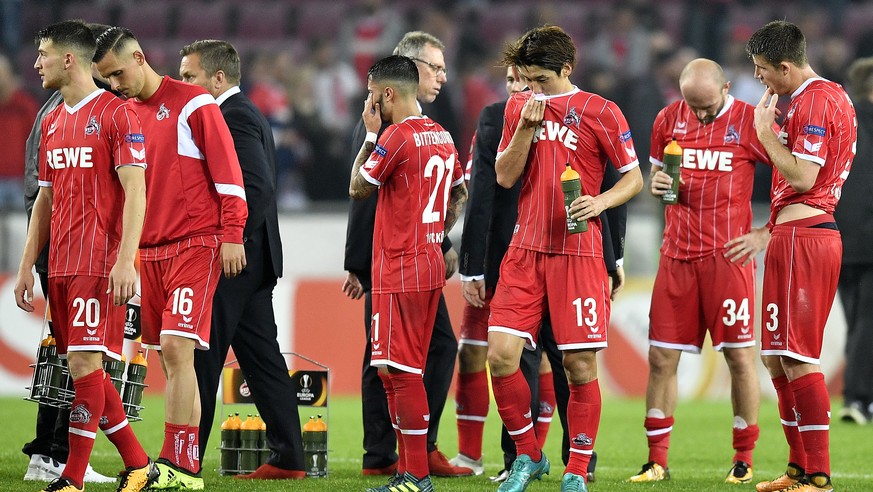 Cologne&#039;s head coach Peter Stoeger, center, and members of the team stay on the pitch after the Europa League group H soccer match between 1.FC Koeln and Crvena zvezda at the Muengersdorfer stadi ...