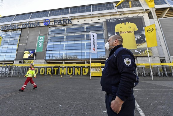 Security with face masks stand in front of the Signal Iduna Park, Germany&#039;s biggest stadium of Bundesliga soccer club Borussia Dortmund, where a temporary coronavirus treatment center opened toda ...