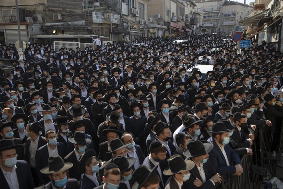 Thousands of ultra-Orthodox Jewish men attend the funeral of Rabbi Aharon David Hadash, the spiritual leader of the Mir Yeshiva, a prominent religious seminary, in Jerusalem, Thursday, Dec. 3, 2020. T ...