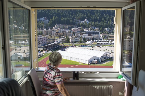 A woman watches the Longines CSI St. Moritz horse jumping from her flat, on Saturday, August 29, 2015, in St. Moritz, canton of Grisons. The show jjumping event takes place for the first time and host ...