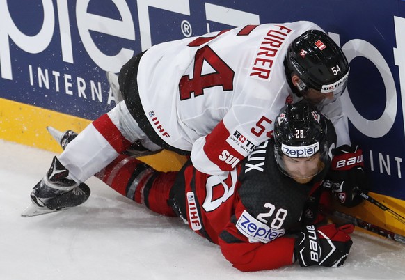 Switzerland&#039;s Philippe Furrer, top, checks Canada&#039;s Claude Giroux, bottom, during the Ice Hockey World Championships group B match between Canada and Switzerland in the AccorHotels Arena in  ...
