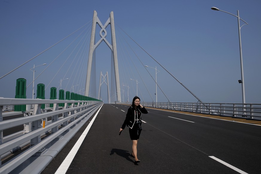 A woman walks on the Hong Kong-Zhuhai-Macau Bridge in Zhuhai city, south China&#039;s Guangdong province, Wednesday, March 28, 2018. The Hong Kong-Zhuhai-Macau Bridge, the world&#039;s longest cross-s ...