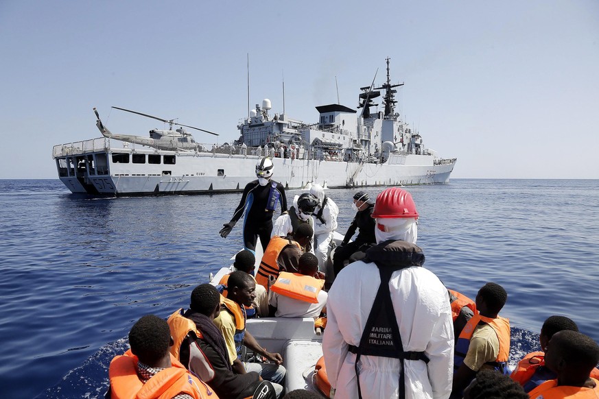 epa04387327 Sub-Saharan migrants are transported to Italian Navy&#039;s frigate &#039;Euro&#039; (background) during rescue operations at an unspecified location in the southern Mediterranean Sea, 06  ...