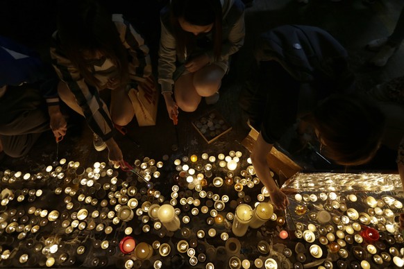 Protesters light candles to pay homage to Chow Tsz-Lok at the site where he fell during an earlier protest in Tseung Kwan O in Hong Kong on Friday, Nov. 8, 2019. Chow, a Hong Kong university student w ...