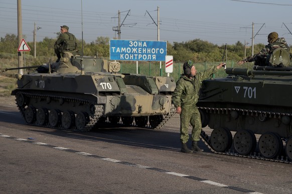 Russian solders with their several military vehicle gather at the rail road crossing about 30 kilometers (19 miles) from Ukrainian border at Rostov-on-Don region, Russia, early Friday, Aug. 15, 2014.  ...