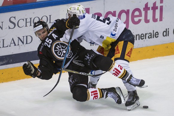 From left, Lugano&#039;s player Maxim Lapierre and Zug&#039;s player Jesse Zgraggen, during the preliminary round game of National League Swiss Championship 2018/19 between HC Lugano and EV Zugo, at t ...