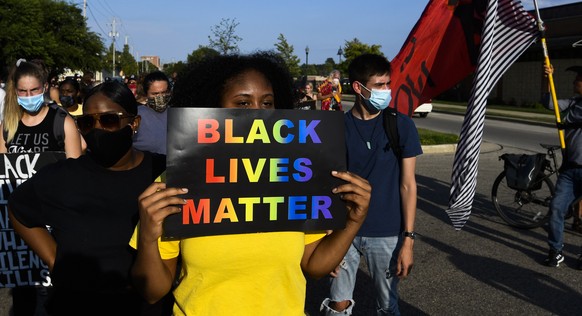 epa08630724 Protestors march durig a demonstration held in the wake of the shooting of Jacob Blake by police officers, in Kenosha, Wisconsin, USA, 27 August 2020. According to media reports Jacob Blak ...