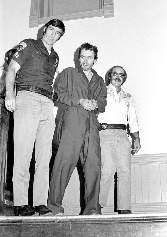 Suspected serial killer Ted Bundy, center, is escorted by authorities down the stairs in Glenwood Springs, Colo., June 13, 1977. Bundy, acting as his own attorney, escaped the courthouse on June 7 by  ...
