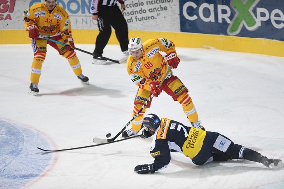 Ambri&#039;s player Isacco Dotti, right, fights for the puck with Biel&#039;s player Damien Brunner, during the preliminary round game of National League Swiss Championship ice hockey game between HC  ...