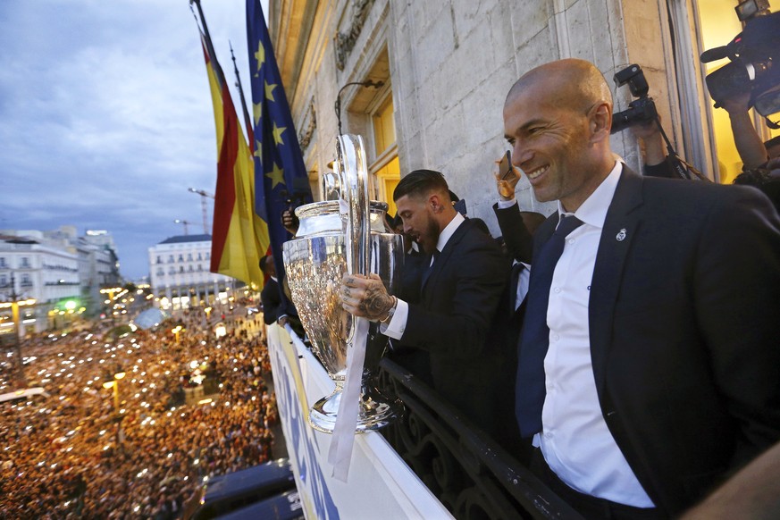epa07429230 (FILE) - Real Madrid&#039;s Sergio Ramos (C) holds the Champions League trophy next to his coach Zinedine Zidane (R) on the balcony of the Madrid Autonomous Government headquarter in Madri ...