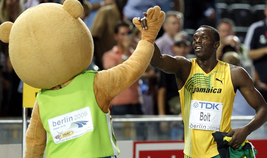 epa01826182 Usain Bolt of Jamaica gives high 5 to the mascot &quot;Berlino&quot; after winning the 100m final at the 12th IAAF World Championships in Athletics, Berlin, Germany, 16 August 2009. EPA/KA ...