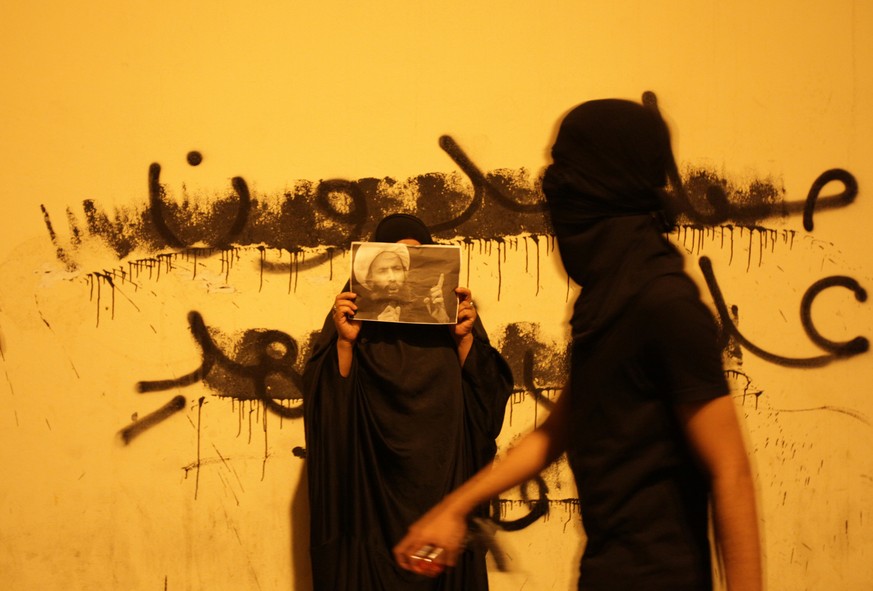 Protest in Bahrain im Oktober 2014: Die Frau hält ein Bild des schiitischen Geistlichen&nbsp;Nimr al-Nimr hoch, der nach Demonstrationen in Bahrain in saudische Gefangenschaft kam.