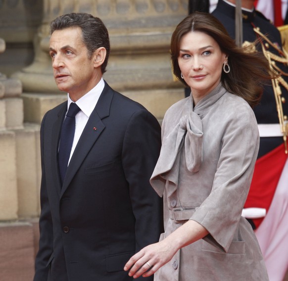 French President Nicolas Sarkozy, left, and his wife Carla Bruni-Sarkozy, right, walk out to greet U.S. President Barack Obama at the Palais Roham in Strasbourg, France, Friday, April 3, 2009. (AP Pho ...