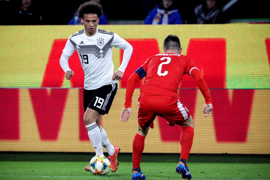 epa07451615 Germany&#039;s Leroy Sane (L) in action against Serbia&#039;s Antonio Rukavina (R) during the international friendly soccer match between Germany and Serbia in Wolfsburg, Germany, 20 March ...