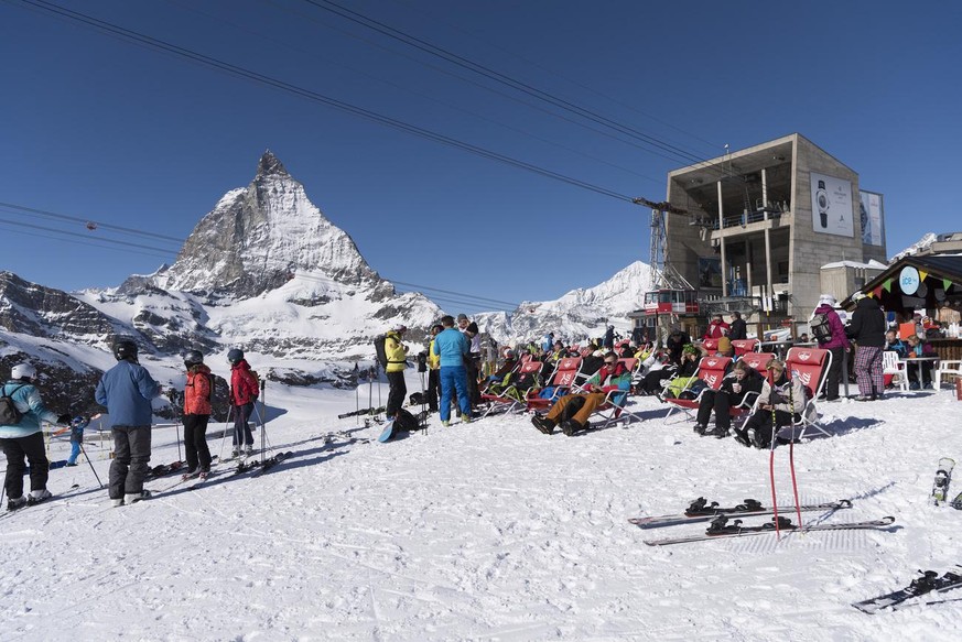 People sitting in deck chairs in the foreground, the Matterhorn in the background, pictured outside the cable car station Trockener Steg above Zermatt, Canton of Valais, Switzerland, on February 13, 2 ...