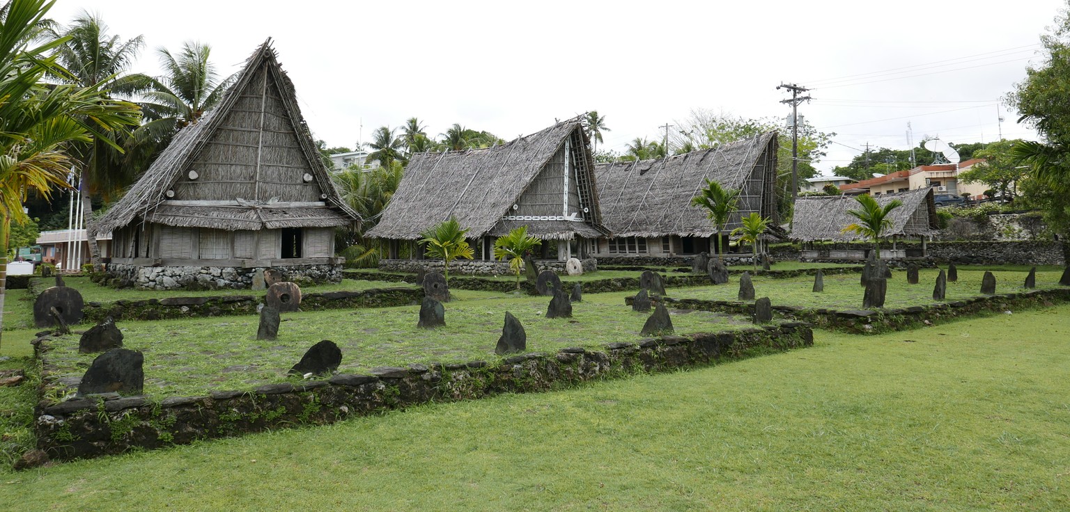 Traditionelle Häuser auf Yap. Auch zu sehen: Das runde Steingeld. Hierher hat es das Coronavirus noch nicht geschafft.