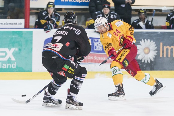 Le defenseur fribourgeois Larri Leeger, gauche, lutte pour le puck avec l&#039;attaquant de Langnau Elo Eero, droite, lors du match du championnat suisse de hockey sur glace de National League A entre ...