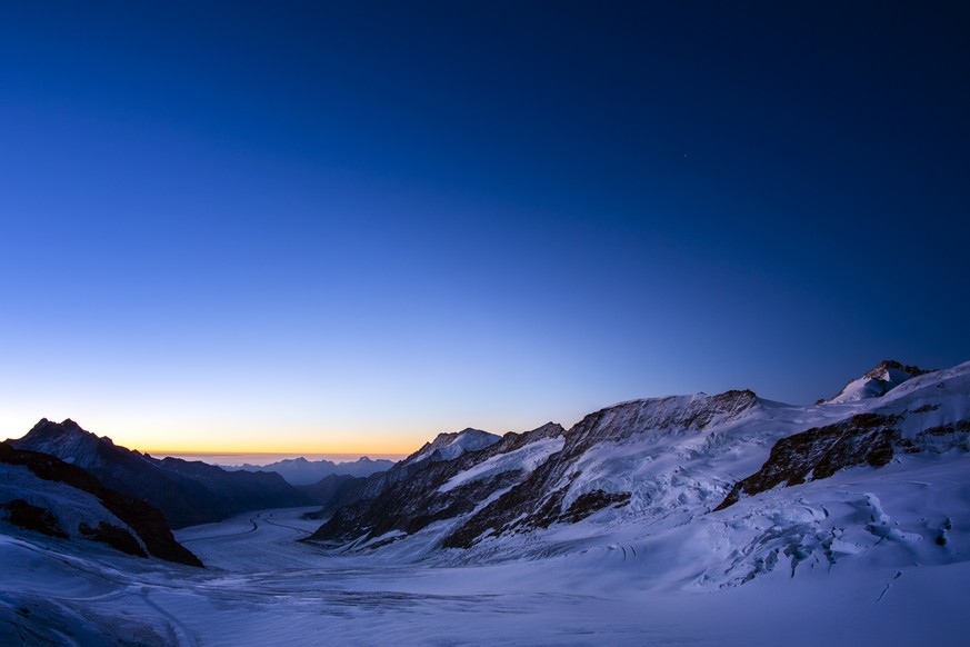 The sun is rising behind the Jungfraufirn and the Aletsch Glacier. Picture was taken from the Jungfraujoch, 3&#039;454 meters above sea level, in the Bernese Alps on the boundary between the canton of ...