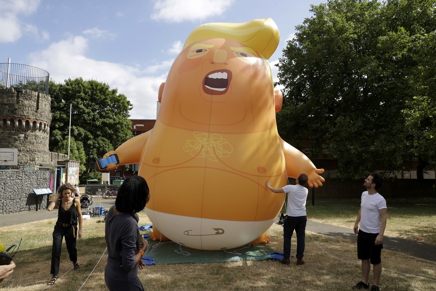 In this photo taken on Tuesday, July 10, 2018, a six-meter high cartoon baby blimp of U.S. President Donald Trump stands inflated during a practice session in Bingfield Park, north London. Trump will  ...