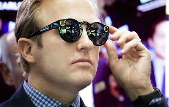 epaselect epa05825337 A banker wearing Snapchat Spectacles watches the initial public offering of Snap Inc, the parent company of Snapchat, at the New York Stock Exchange in New York, New York, USA, o ...