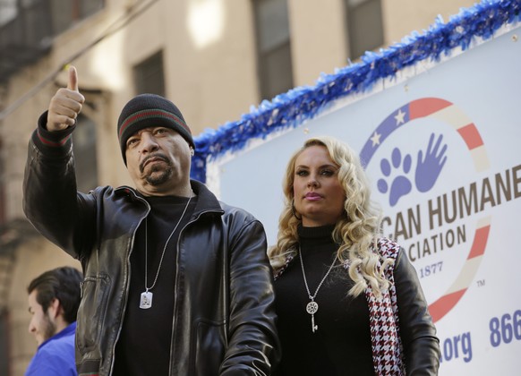 Rapper Ice-T gives a thumbs up with his wife Coco at his side as they ride aboard a float honoring retired military service animals during the 2014 annual Veterans Day parade in New York, Tuesday, Nov ...
